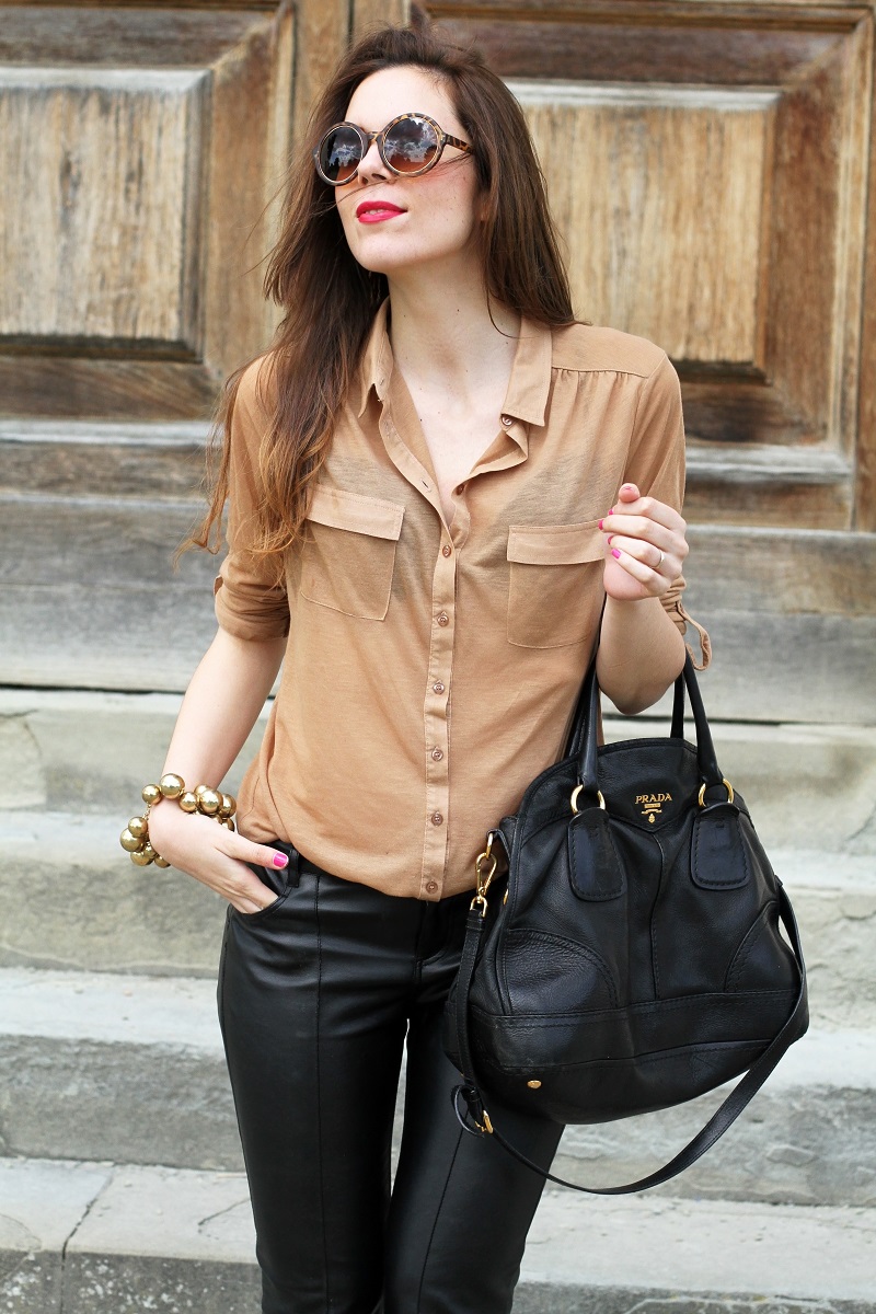 pantaloni di pelle nera | pelle | camicia beige | camicia marrone | braccialetto grande | occhiali da sole rotondi | smalto fucsia | occhiali da sole | fashion | moda | outfit | look | streetstyle | irene colzi