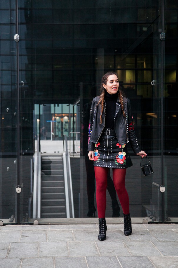 look calze rosse giacca in pelle e gonna in pelle con fiori ricamati
